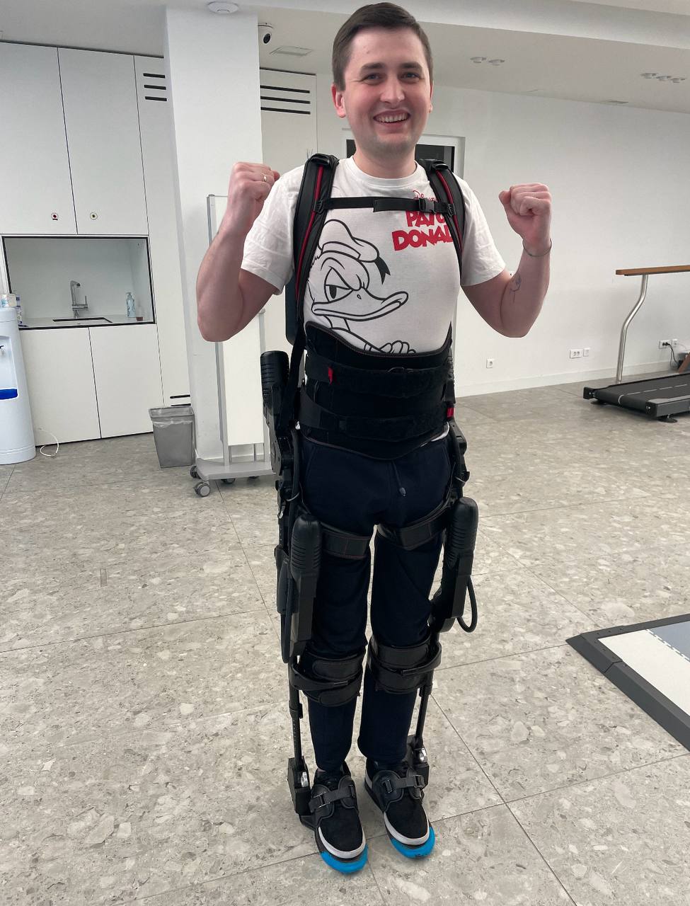 Igor standing in a robotic exoskeleton, smiling